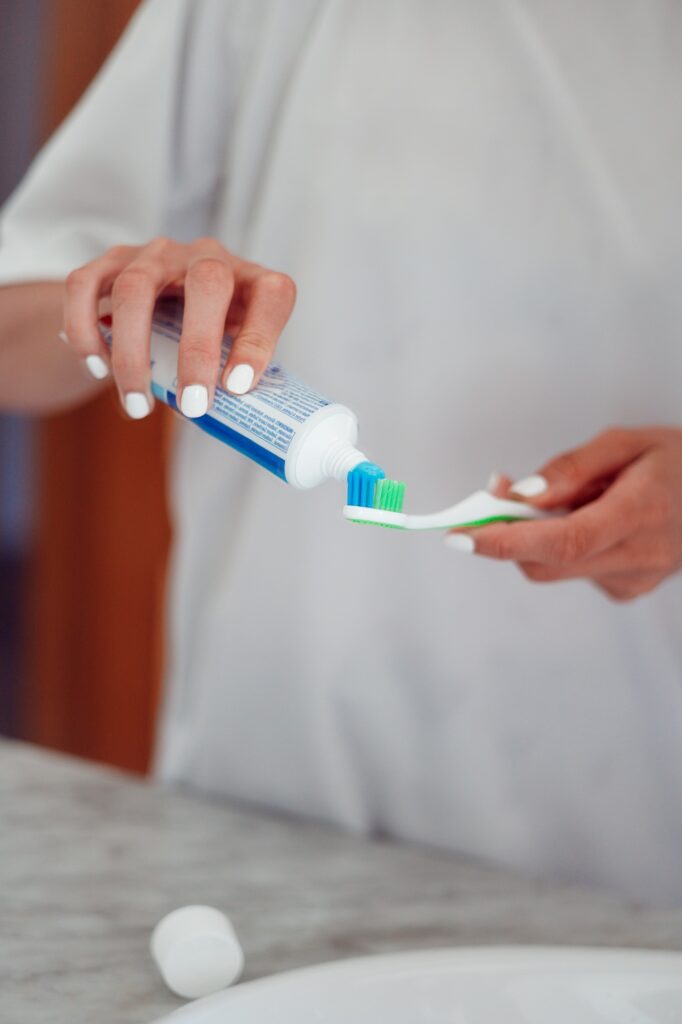 Woman hands holding toothpaste and toothbrush