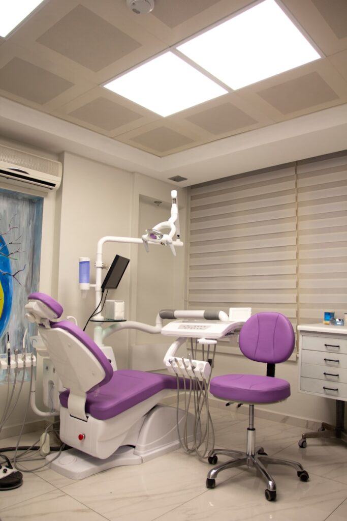 a dental room with a purple chair and a white desk